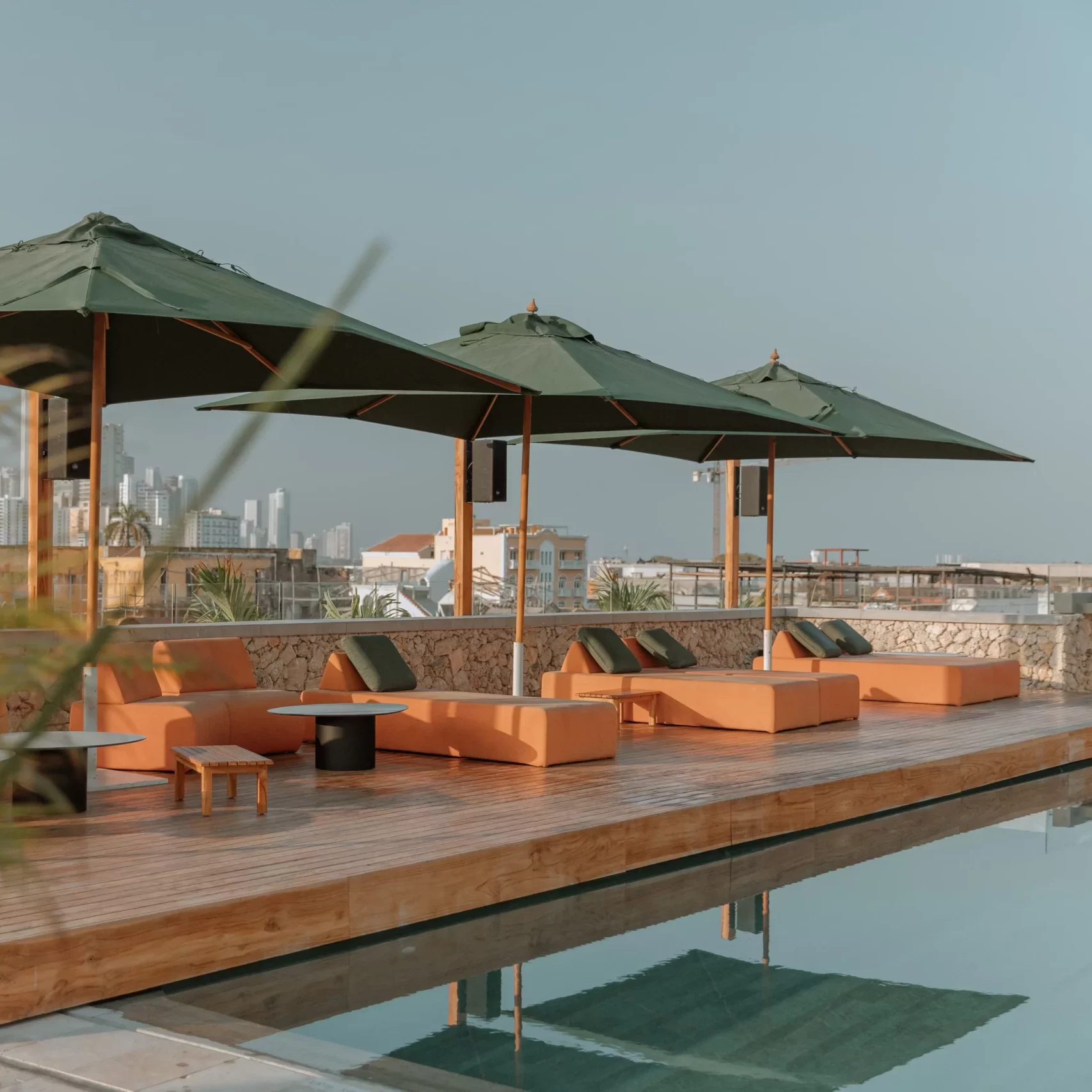 Rooftop terrace with sunbeds and umbrellas facing Cartagena skyline