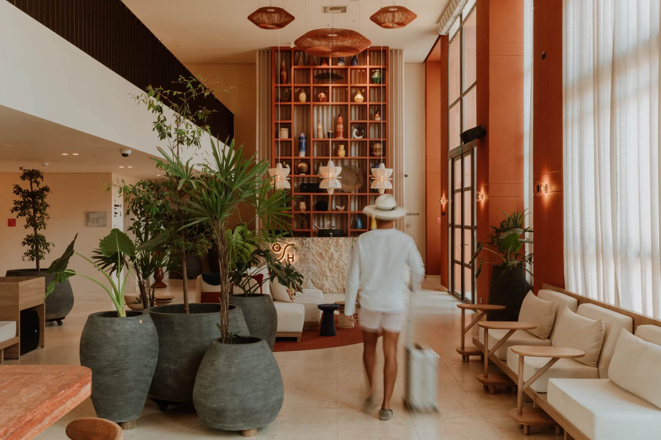 Guest entering tropical design lobby at OSH Hotel Cartagena
