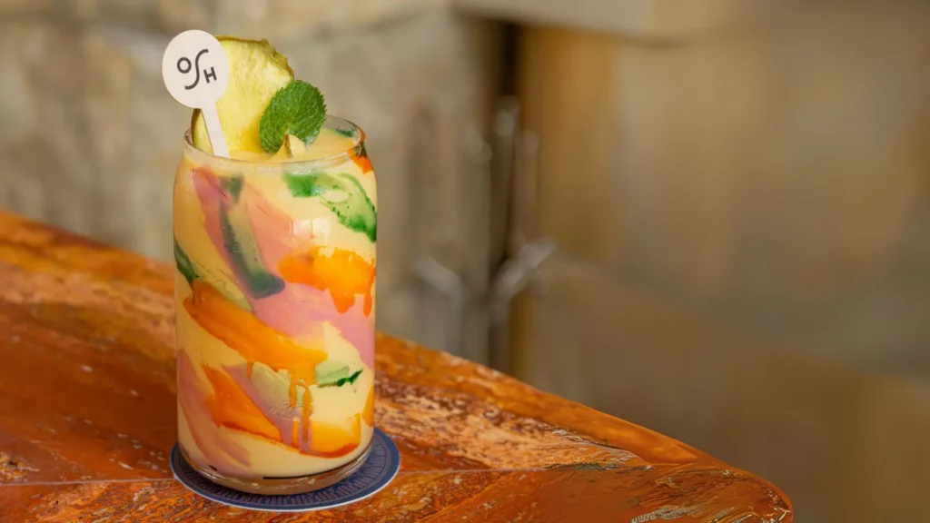 Colorful tropical smoothie with pineapple and mint garnish at Carta Ajena.