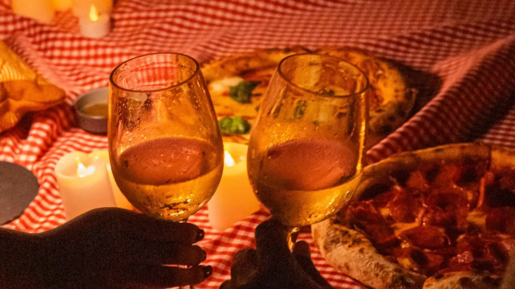 Brindis con vino blanco y pizza artesanal bajo la luz de velas en Night Picnic de Cartagena