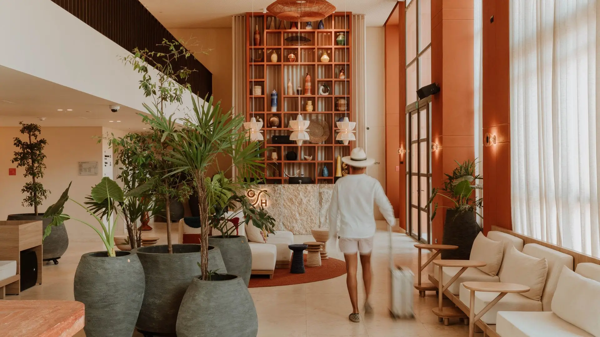 Guest arriving at the OSH Hotel lobby, carrying their luggage.