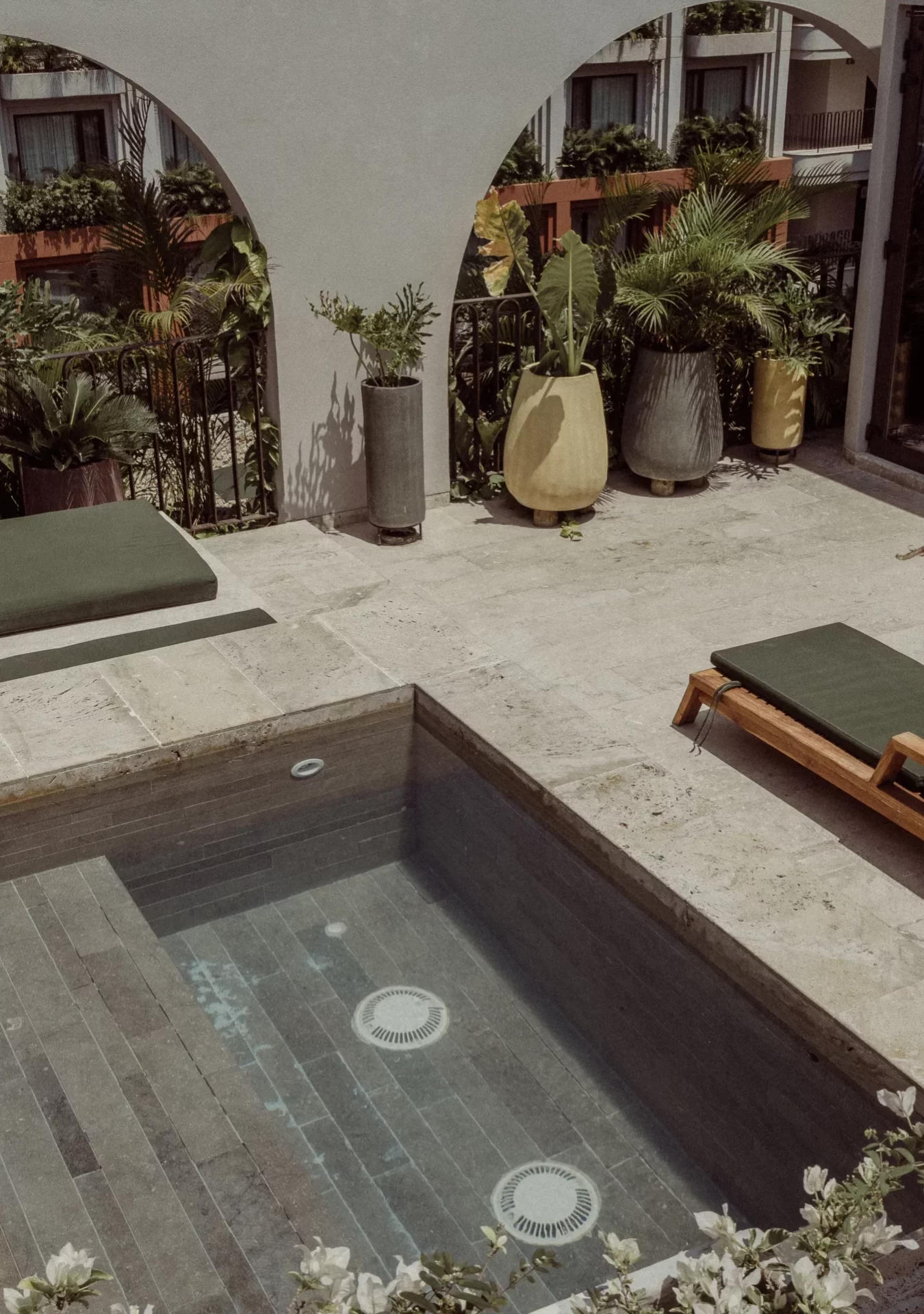 Outdoor jacuzzi surrounded by loungers and plants in Cool King room